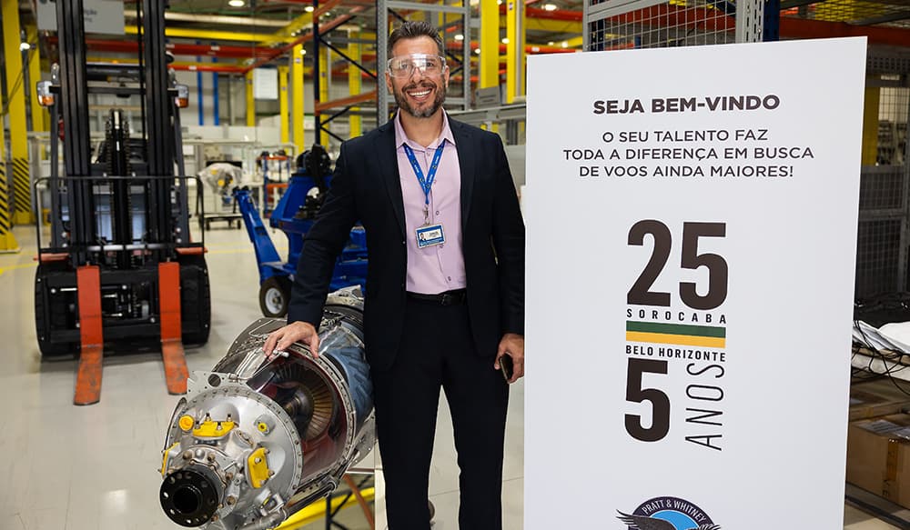 Homem com uma turbina no lado esquerdo e uma placa do evento no lado direito