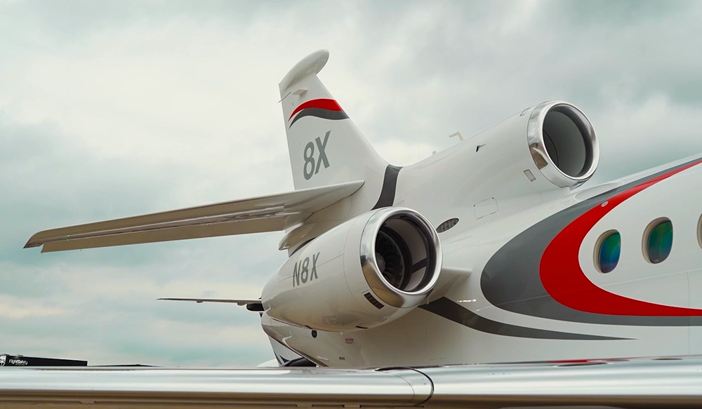 Foto da parte de trás de um jato 8X da Dassault Falton e uma parte da asa direita na parte inferior da foto